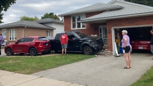 Truck comes to rest on steps of home after hitting parked car