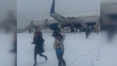 Passengers evacuate plane on snowy tarmac amid storm