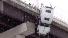 Watch: Driver hoisted to safety from truck dangling over West Virginia bridge